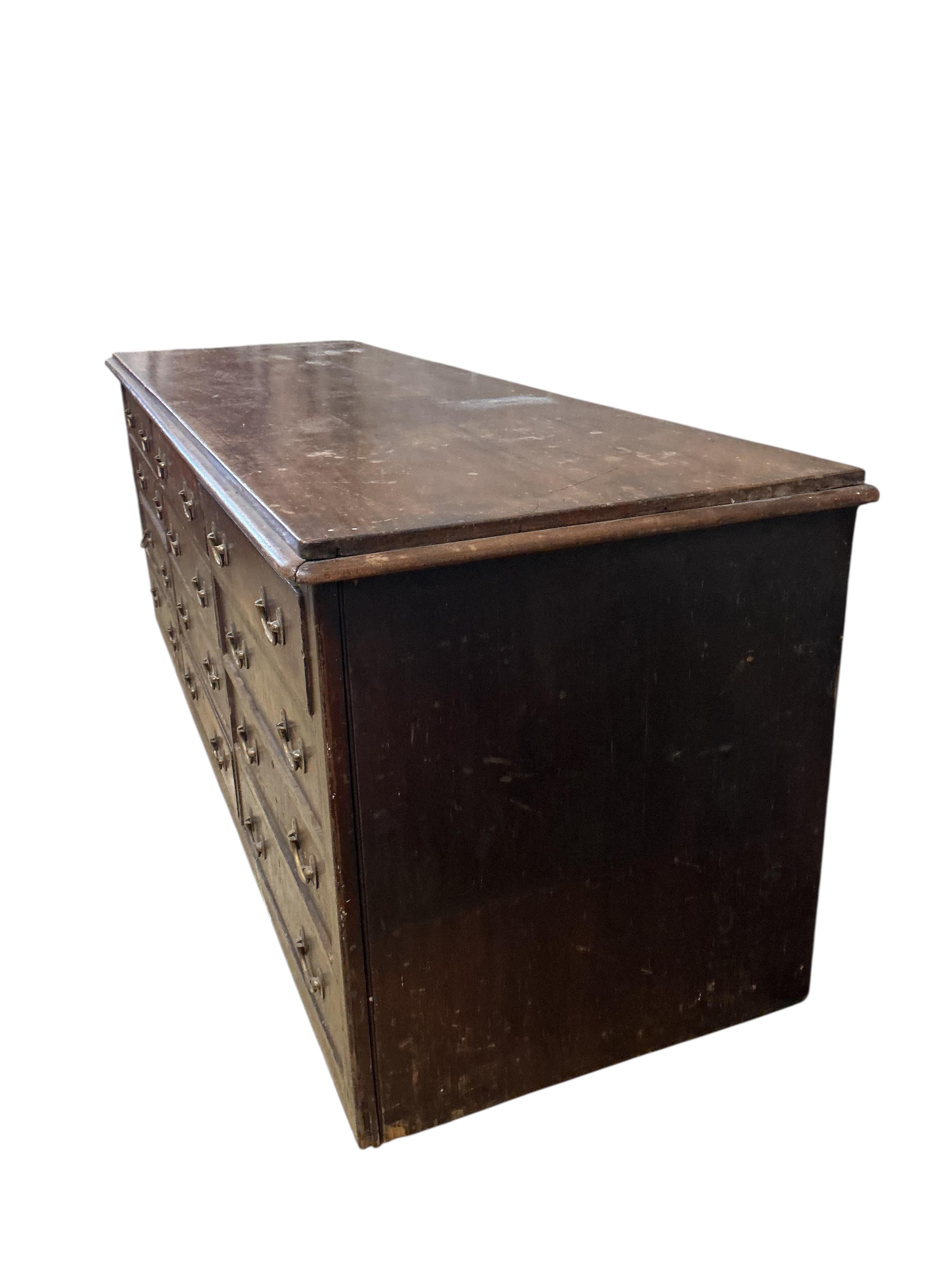 A Victorian mahogany twelve drawer shop counter, width 252cm, depth 78cm, height 87cm